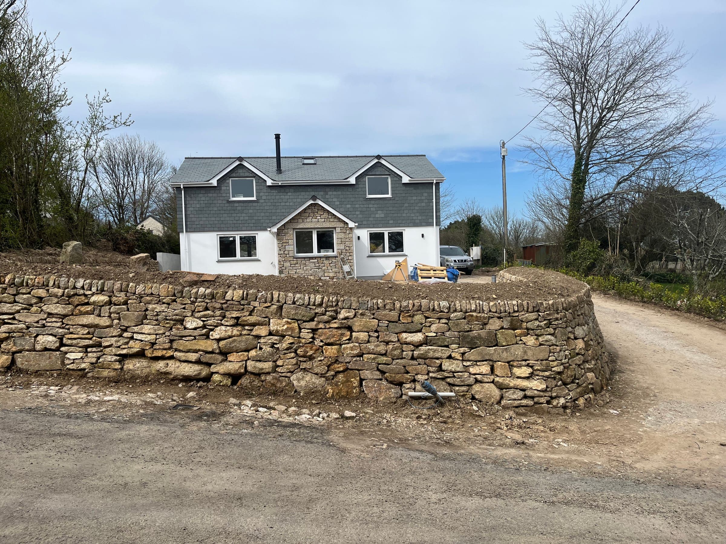 Mitchell & Andrew Building Services — Family home with slate roof and dry-stone wall